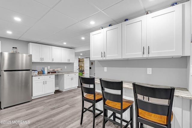 1020 Aumack Rd, Jackson, NJ 08527 - kitchen with freestanding refrigerator, white cabinets, recessed lighting, light stone counters, and light wood-style flooring