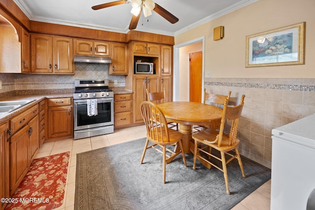117 Greymoor Rd, Howell, NJ 07731 - kitchen with stainless steel appliances, under cabinet range hood, light tile patterned floors, a ceiling fan, and ornamental molding
