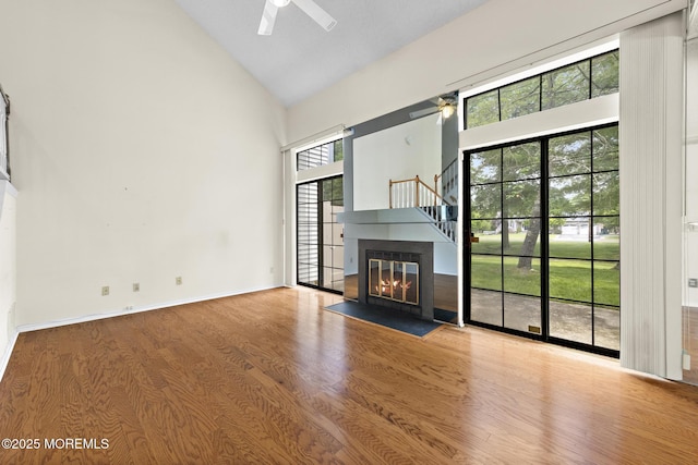 11 Old Orchard Ln, Ocean Twp, NJ 07712 - unfurnished living room featuring high vaulted ceiling, a ceiling fan, wood finished floors, and a fireplace with flush hearth