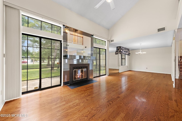 11 Old Orchard Ln, Ocean Twp, NJ 07712 - unfurnished living room with a chandelier, a fireplace with flush hearth, high vaulted ceiling, ceiling fan, and healthy amount of natural light