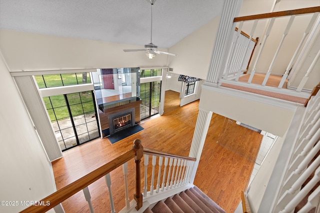 11 Old Orchard Ln, Ocean Twp, NJ 07712 - stairs with wood finished floors, vaulted ceiling, ceiling fan, and a fireplace with flush hearth