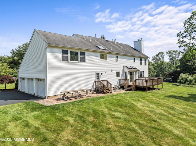 20 Birch Ln, Colts Neck, NJ 07722 - back of property featuring a deck, asphalt driveway, a chimney, a lawn, and an attached garage