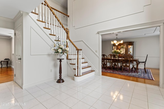 20 Birch Ln, Colts Neck, NJ 07722 - foyer entrance featuring ornamental molding, stairs, a chandelier, and light tile patterned floors