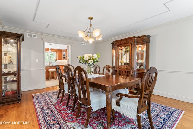 20 Birch Ln, Colts Neck, NJ 07722 - dining area featuring light wood-style floors, ornamental molding, and a chandelier