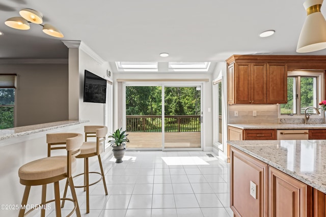 20 Birch Ln, Colts Neck, NJ 07722 - kitchen featuring light tile patterned floors, healthy amount of natural light, brown cabinets, crown molding, and recessed lighting
