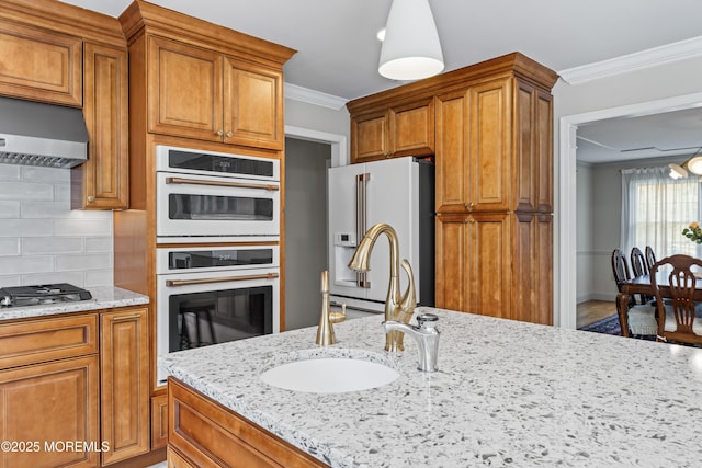 20 Birch Ln, Colts Neck, NJ 07722 - kitchen with fridge with ice dispenser, white double oven, ornamental molding, tasteful backsplash, and light stone counters