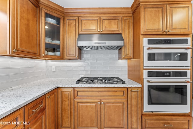 20 Birch Ln, Colts Neck, NJ 07722 - kitchen with white double oven, range hood, stainless steel gas cooktop, backsplash, and brown cabinets