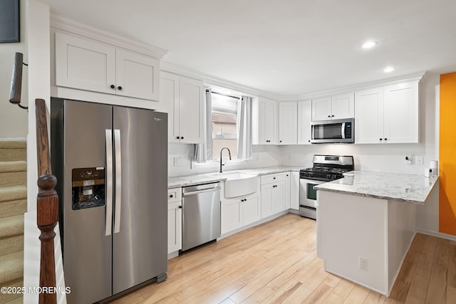 15 Haven Way, Keyport, NJ 07735 - kitchen featuring appliances with stainless steel finishes, a peninsula, light wood-type flooring, white cabinets, and light stone countertops