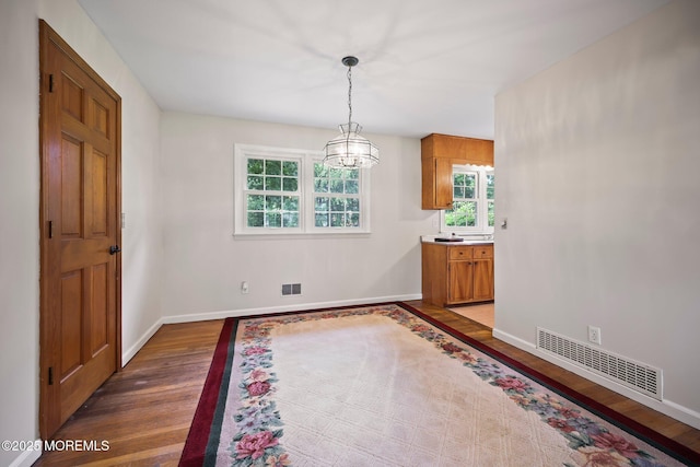 3 Mcelwaine Dr, Freehold, NJ 07728 - unfurnished dining area featuring wood finished floors, healthy amount of natural light, and a chandelier