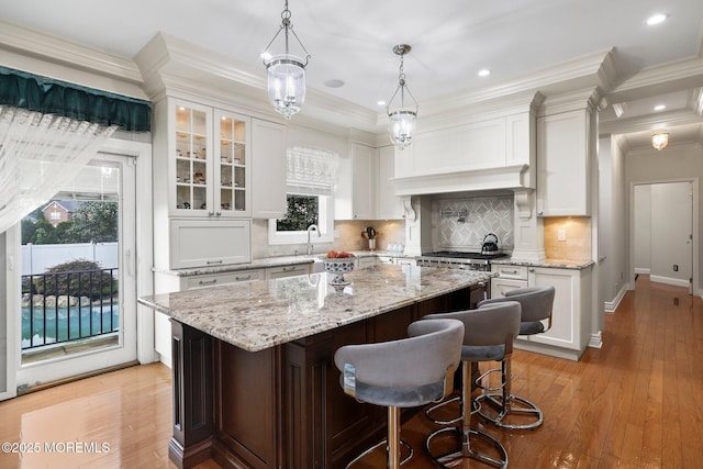 43 Shawnee Way, Morganville, NJ 07751 - kitchen featuring white cabinetry, ornamental molding, tasteful backsplash, a breakfast bar area, and a kitchen island