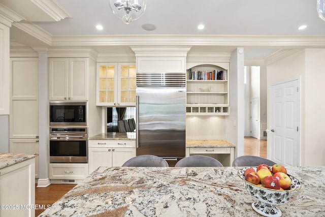 43 Shawnee Way, Morganville, NJ 07751 - kitchen with built in appliances, dark wood-style floors, light stone countertops, ornamental molding, and glass insert cabinets