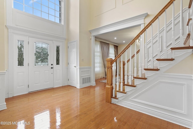 43 Shawnee Way, Morganville, NJ 07751 - entrance foyer with a decorative wall, a wainscoted wall, hardwood / wood-style flooring, stairway, and a high ceiling