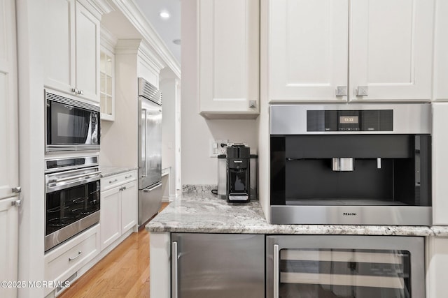 43 Shawnee Way, Morganville, NJ 07751 - kitchen with wine cooler, built in appliances, white cabinets, light wood-style floors, and recessed lighting