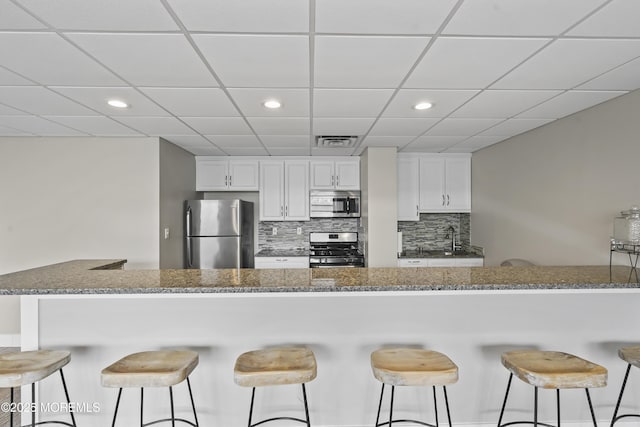 675 Ocean Ave # 9F, Long Branch, NJ 07740 - kitchen with stainless steel appliances, backsplash, white cabinetry, recessed lighting, and dark stone countertops