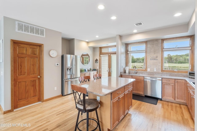 85 Channel Dr, Brick, NJ 08723 - kitchen with stainless steel appliances, light stone countertops, light wood-style flooring, a breakfast bar area, and a kitchen island