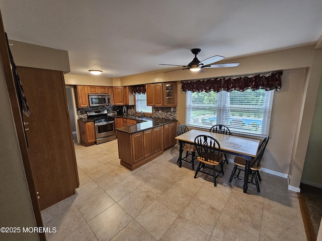 217 Betsy Ross Dr, Freehold, NJ 07728 - kitchen with stainless steel appliances, dark countertops, brown cabinetry, a ceiling fan, and decorative backsplash