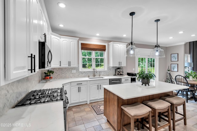 15 Conor Rd, Jackson, NJ 08527 - kitchen with appliances with stainless steel finishes, tasteful backsplash, white cabinets, a kitchen bar, and ornamental molding