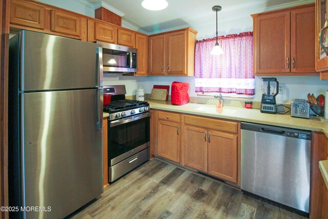 26 Pine Ridge Blvd, Whiting, NJ 08759 - kitchen with appliances with stainless steel finishes, crown molding, light countertops, wood finished floors, and brown cabinetry
