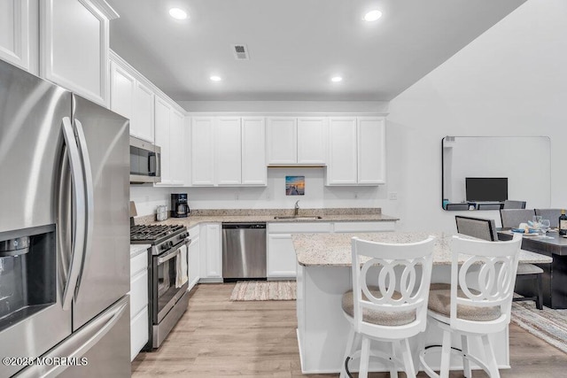 73 Aqueduct Blvd, New Egypt, NJ 08533 - kitchen with stainless steel appliances, white cabinets, light stone counters, a breakfast bar, and recessed lighting