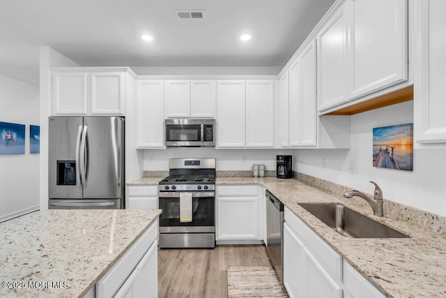 73 Aqueduct Blvd, New Egypt, NJ 08533 - kitchen with appliances with stainless steel finishes, white cabinets, light wood-type flooring, recessed lighting, and light stone countertops