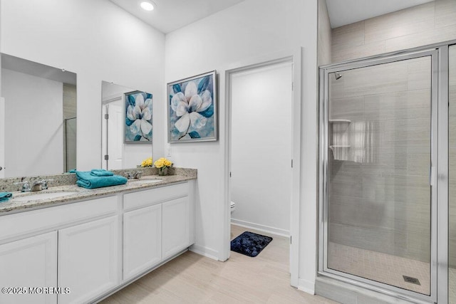 73 Aqueduct Blvd, New Egypt, NJ 08533 - bathroom featuring double vanity, a shower stall, and wood finished floors
