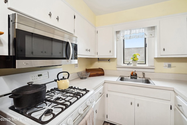 124 Mckinnon St, Piscataway Twp, NJ 08854 - kitchen with white range with gas stovetop, stainless steel microwave, white cabinets, and light countertops