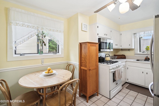 124 Mckinnon St, Piscataway Twp, NJ 08854 - kitchen with appliances with stainless steel finishes, ceiling fan, light tile patterned flooring, and white cabinetry