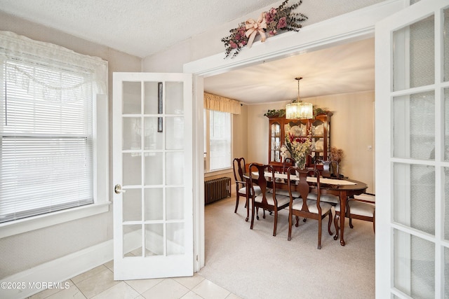 124 Mckinnon St, Piscataway Twp, NJ 08854 - dining space featuring radiator heating unit, a chandelier, light carpet, and light tile patterned floors