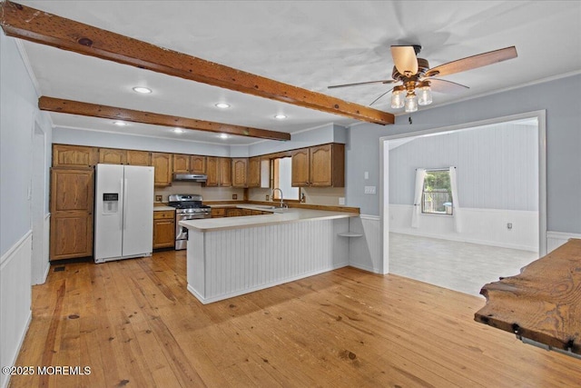 367 Marine St, Tuckerton, NJ 08087 - kitchen with white fridge with ice dispenser, gas range, light wood-style flooring, brown cabinetry, and under cabinet range hood