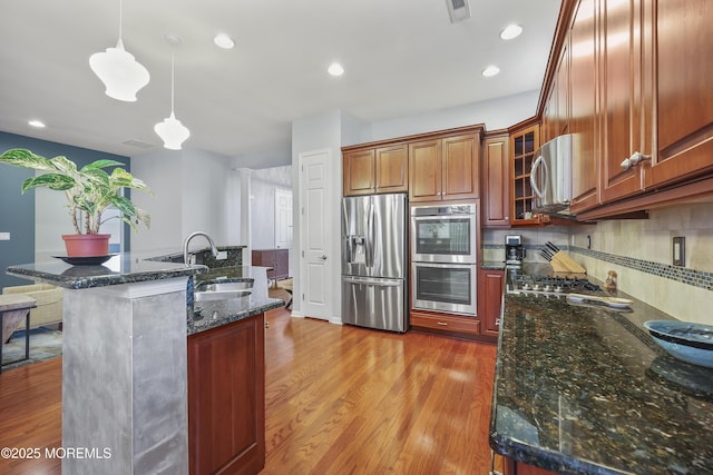 130 Masters Dr, Monroe, NJ 08831 - kitchen featuring stainless steel appliances, decorative backsplash, light wood-style floors, hanging light fixtures, and dark stone countertops