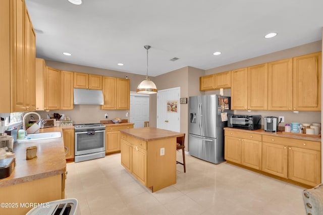 47 Lori St, Monroe, NJ 08831 - kitchen with stainless steel appliances, under cabinet range hood, light brown cabinetry, a kitchen island, and light countertops