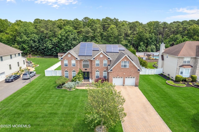 47 Lori St, Monroe, NJ 08831 - view of front of home with solar panels, decorative driveway, an attached garage, and brick siding