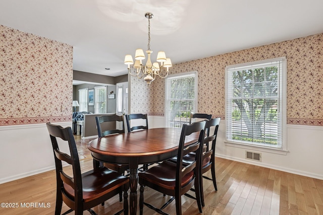 404 5th Ave, Spring Lake, NJ 07762 - dining area featuring wallpapered walls, a chandelier, wainscoting, and light wood-style flooring
