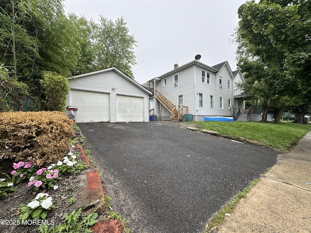 1029 1st Ave, Asbury Park, NJ 07712 - view of front facade featuring a garage, an outbuilding, and stairs