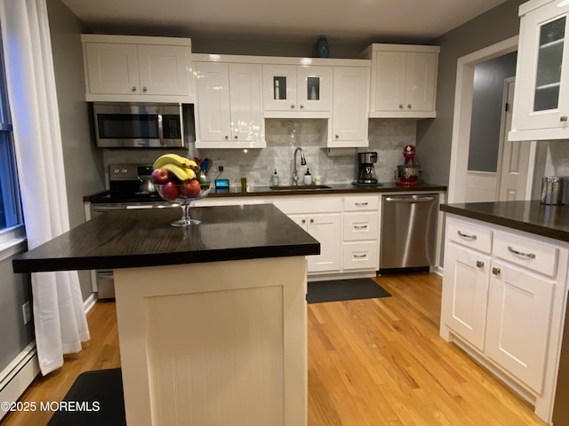3 Maria Ct, Brick, NJ 08724 - kitchen featuring stainless steel appliances, dark countertops, light wood finished floors, tasteful backsplash, and white cabinetry