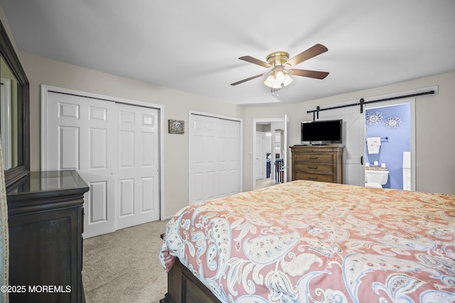 39 Sweet Gum Rd, Howell, NJ 07731 - carpeted bedroom featuring two closets, a barn door, ensuite bath, and a ceiling fan