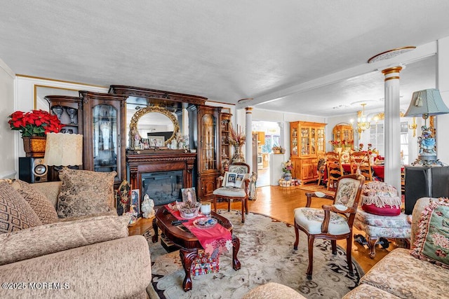 426 Shady Ln, Howell, NJ 07731 - living room with decorative columns, a chandelier, a glass covered fireplace, and wood finished floors