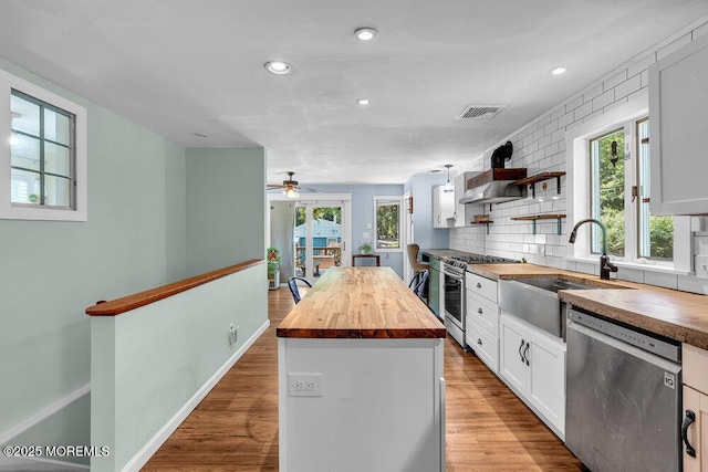 276 Chandler Rd, Jackson, NJ 08527 - kitchen featuring butcher block countertops, appliances with stainless steel finishes, a center island, white cabinetry, and wood finished floors