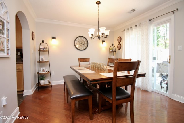 20 Atlantis Ter, Freehold, NJ 07728 - dining area featuring dark wood-style flooring, ornamental molding, arched walkways, and a chandelier