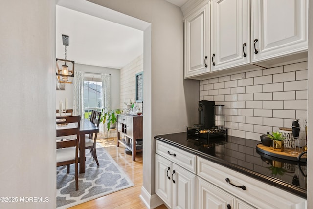 43 Sweet Gum Rd, Howell, NJ 07731 - kitchen featuring dark countertops, light wood-type flooring, tasteful backsplash, white cabinetry, and hanging light fixtures