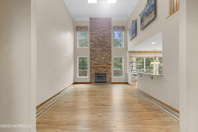 3 Canterbury Ct, Jackson, NJ 08527 - unfurnished living room featuring wood finished floors, a high ceiling, ornamental molding, a stone fireplace, and a chandelier