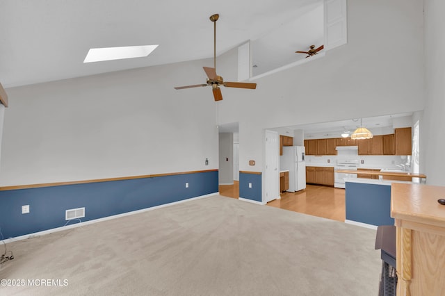 23 Dexter Ln, Jackson, NJ 08527 - unfurnished living room featuring light carpet, a skylight, high vaulted ceiling, and a ceiling fan