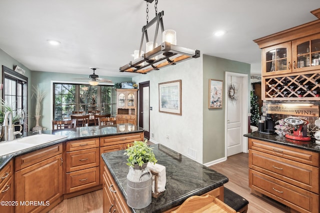 648 Point Ave, Brick, NJ 08724 - kitchen featuring ceiling fan, light wood-type flooring, a kitchen island, glass insert cabinets, and brown cabinetry