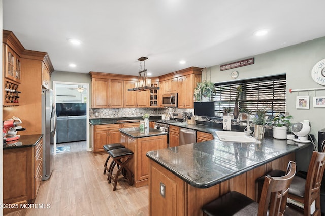 648 Point Ave, Brick, NJ 08724 - kitchen with appliances with stainless steel finishes, a peninsula, light wood-style floors, decorative backsplash, and glass insert cabinets