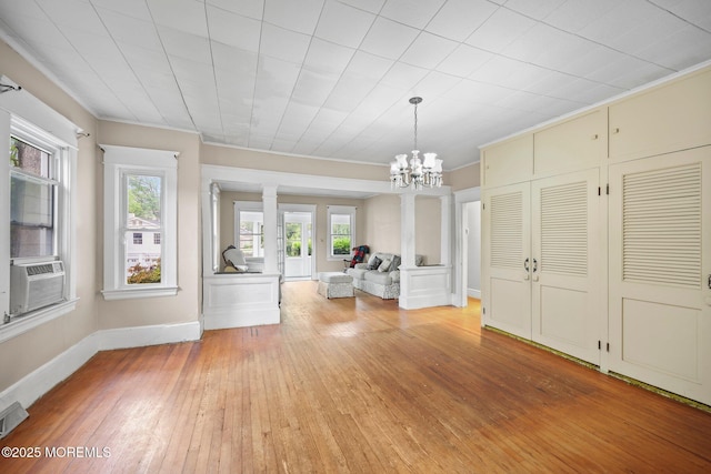 16 Steiner Ave, Neptune City, NJ 07753 - unfurnished living room with ornamental molding, light wood-style flooring, ornate columns, a chandelier, and cooling unit