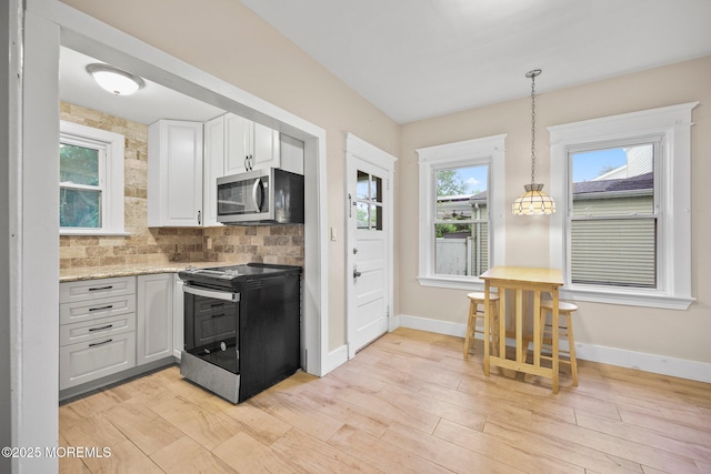 16 Steiner Ave, Neptune City, NJ 07753 - kitchen with appliances with stainless steel finishes, white cabinets, tasteful backsplash, light wood-style flooring, and decorative light fixtures