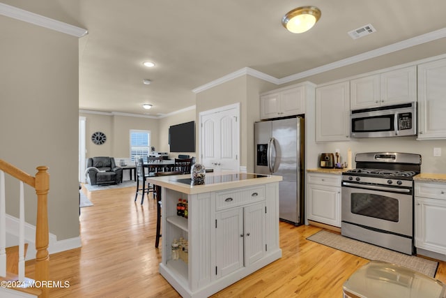 119 Dupont Ave Unit 2A, Seaside Heights, NJ 08751 - kitchen with appliances with stainless steel finishes, white cabinetry, light countertops, light wood-type flooring, and ornamental molding