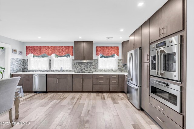 13 Canaries Ct, Toms River, NJ 08757 - kitchen with stainless steel appliances, light countertops, light wood-type flooring, dark brown cabinetry, and recessed lighting