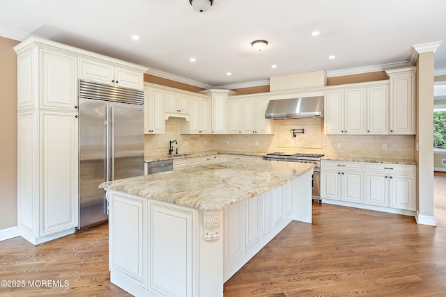 7 Rodeo Ct, Howell, NJ 07731 - kitchen featuring high quality appliances, wall chimney range hood, a kitchen island, tasteful backsplash, and light wood finished floors
