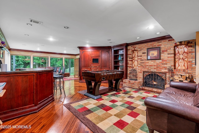 25 Canadian Woods Rd, Marlboro, NJ 07746 - game room with a fireplace, crown molding, and light wood-style flooring